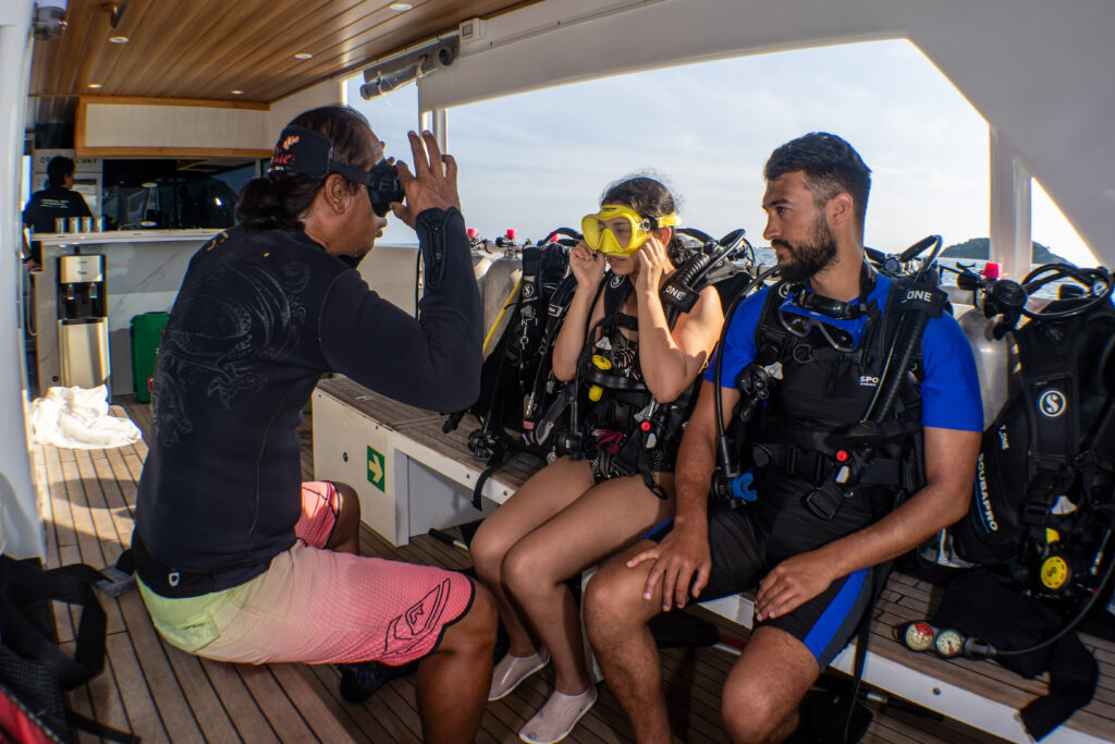A PADI instructor conducting a personalized safety briefing for a small group of scuba divers at YBD Dive Centre